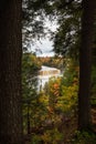 Beautiful autumn photograph of Upper Tahquamenon Falls in Michigan with water cascading into the river below framed between trees Royalty Free Stock Photo