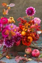 Beautiful autumn pink red orange bouquet with dahlia, fall flowers, colorful leaves and apples Royalty Free Stock Photo