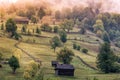 Beautiful autumn rural landscape with old houses, trees, fences and fog Royalty Free Stock Photo