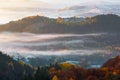 Beautiful autumn rural scenery. Landscape with amazing mountains, fields and forests covered with morning fog. Carpathians.