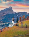 Impressive autumn view of Santa Barbara church, San Genesio village location, Province of Bolzano