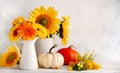 Beautiful autumn still life with bouquet of red and yellow flowers in white vases and white and orange pumpkins on wooden table, Royalty Free Stock Photo