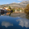 Beautiful autumn view of Trebisnjica river and Trebinje city. White clouds reflected in water. Bosnia and Herzegovina