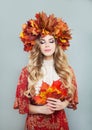 Beautiful autumn woman in bright fall leaves crown with red maple leaf