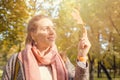 Beautiful autumn woman holding yellow maple leaf outdoors. Romantic girl in fall park Royalty Free Stock Photo