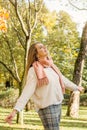 Beautiful autumn woman holding yellow maple leaf outdoors. Romantic girl and spirit autumn in fall park Royalty Free Stock Photo