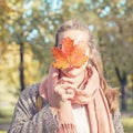 Beautiful autumn woman holding yellow maple leaf. Romantic girl in fall park Royalty Free Stock Photo