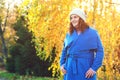 Beautiful autumn woman outdoors. Woman fashion. Young woman dressed in blue coat and warm hat, walking in autumn park. Beautiful