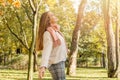 Beautiful autumn woman smiling and looking at sun. Romantic girl in fall park Royalty Free Stock Photo