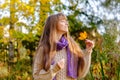 Beautiful autumn woman standing near colorful autumn leaves. Pretty happy cheerful model looking at camera. Young woman Royalty Free Stock Photo