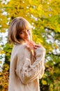 Beautiful autumn woman standing near colorful autumn leaves. Pretty happy cheerful model looking at camera. Young woman Royalty Free Stock Photo