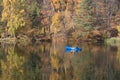 Forest reflected in a lake in Autumn with boat Royalty Free Stock Photo