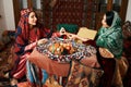 Beautiful azeri women and novruz tray with traditional pastry shekerbura and pakhlava