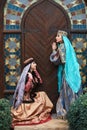 Beautiful azeri women in traditional Azerbaijani dress knocking the wooden door