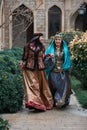 Beautiful azeri women in traditional Azerbaijani dress running by the wooden door