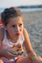 Beautiful babe eats a slice of pizza on the beach