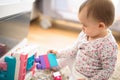 Beautiful baby building with plastic blocks in bright room. Education concept. 6 - 12 month old child Royalty Free Stock Photo