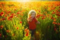 Beautiful baby child with red flowers. Little symbol of love. Family and happiness. Boy in the field.