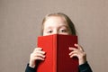 Beautiful baby covering her face with a book.