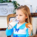 A beautiful baby drinks milk and eats cookies. Breakfast. Concep Royalty Free Stock Photo