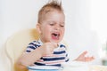 Beautiful baby eating soup with his hands Royalty Free Stock Photo