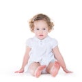 Beautiful baby girl with curly hair in nice white dress