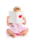 Beautiful baby girl with cute valentine postcard with a red hear