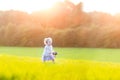 Beautiful baby girl in field on sunny autumn evening