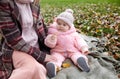 Beautiful baby girl with mother sitting on the plaid. Family outdoor Royalty Free Stock Photo