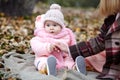Beautiful baby girl with mother sitting on the plaid. Family outdoor Royalty Free Stock Photo