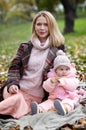 Beautiful baby girl with mother sitting on the plaid. Family outdoor Royalty Free Stock Photo