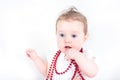 Beautiful baby girl playing with a red necklace Royalty Free Stock Photo