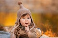 Beautiful baby girl sitting on the plaid near pond. Child outdoor. Baby at picnic in autumn park on sunny day. Pretty Royalty Free Stock Photo