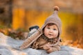 Beautiful baby girl sitting on the plaid near pond. Child outdoor. Baby at picnic in autumn park on sunny day. Pretty little girl Royalty Free Stock Photo