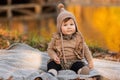 Beautiful baby girl sitting on the plaid near pond. Child outdoor. Baby at picnic in autumn park on sunny day. Pretty little girl Royalty Free Stock Photo