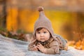 Beautiful baby girl sitting on the plaid near pond. Child outdoor. Baby at picnic in autumn park on sunny day. Pretty little girl Royalty Free Stock Photo