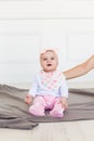 Beautiful baby girl smiling happily. Pink panths and white shirt. 6 months old girl