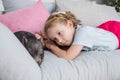 Beautiful baby girl on sofa near a black vietnamese piglet. Concept of the Chinese New Year 2019 of the Pig.Mini piggy Royalty Free Stock Photo