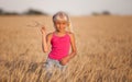 Beautiful baby girl with white hair in a wheat field in summer