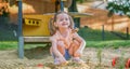 Beautiful baby having fun on sunny warm summer day - Cute toddler girl playing in sand on outdoor playground Royalty Free Stock Photo