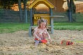 Beautiful baby having fun on sunny warm summer day - Cute toddler girl playing in sand on outdoor playground Royalty Free Stock Photo