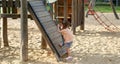 Beautiful baby having fun on sunny warm summer day - Cute toddler girl playing in sand on outdoor playground Royalty Free Stock Photo