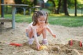Beautiful baby  having fun on sunny warm summer day - Cute toddler girl playing in sand on outdoor playground Royalty Free Stock Photo