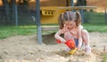 Beautiful baby  having fun on sunny warm summer day - Cute toddler girl playing in sand on outdoor playground Royalty Free Stock Photo