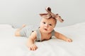 Beautiful baby lies on bed smiling bow on her head Royalty Free Stock Photo