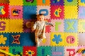 Beautiful baby lying on her back funny playing in her colorful room and protected against bumps Royalty Free Stock Photo