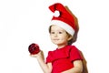 Beautiful baby in red dress holds a glass ball on new year Royalty Free Stock Photo