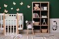 Beautiful baby room interior with stylish furniture and comfortable crib Royalty Free Stock Photo