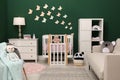 Beautiful baby room interior with stylish furniture and comfortable crib Royalty Free Stock Photo