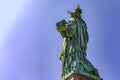 Beautiful back photo of the Statue of Liberty holding her torch on a sunny day in Manhattan, known as the lady of New York City Royalty Free Stock Photo